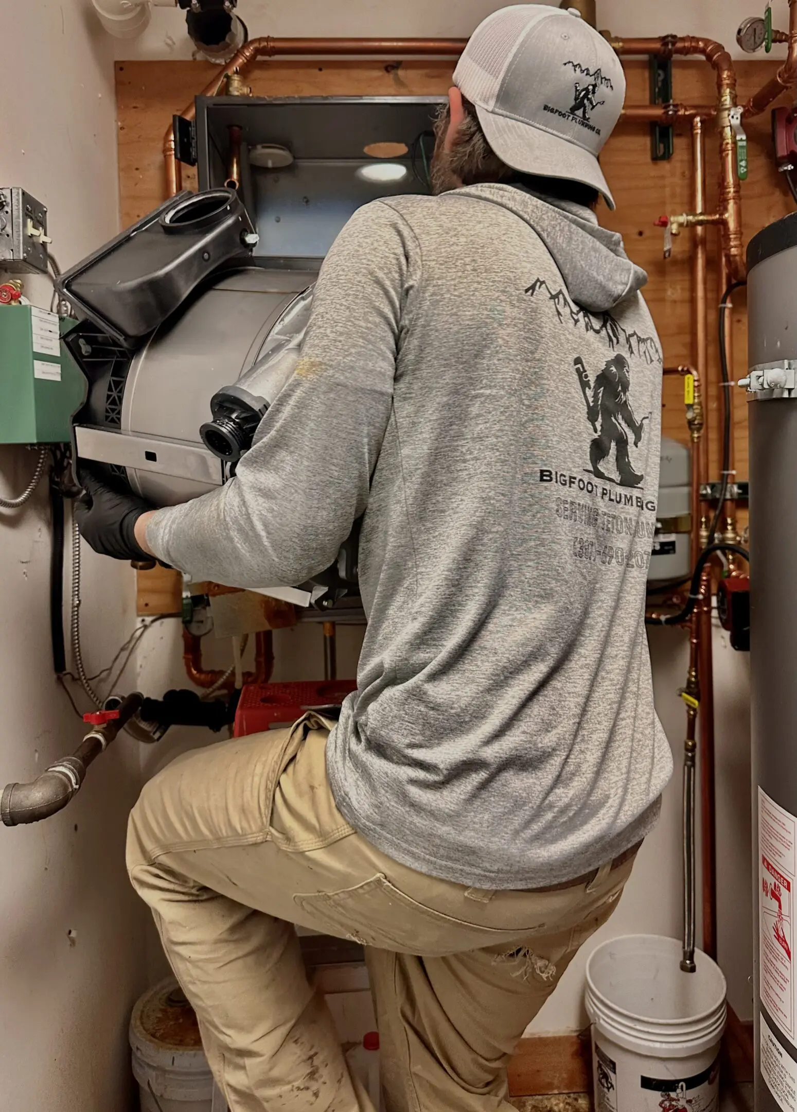 Person working on heating system installation.