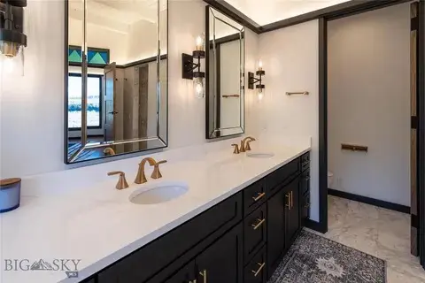 Modern bathroom with double sinks and mirrors.