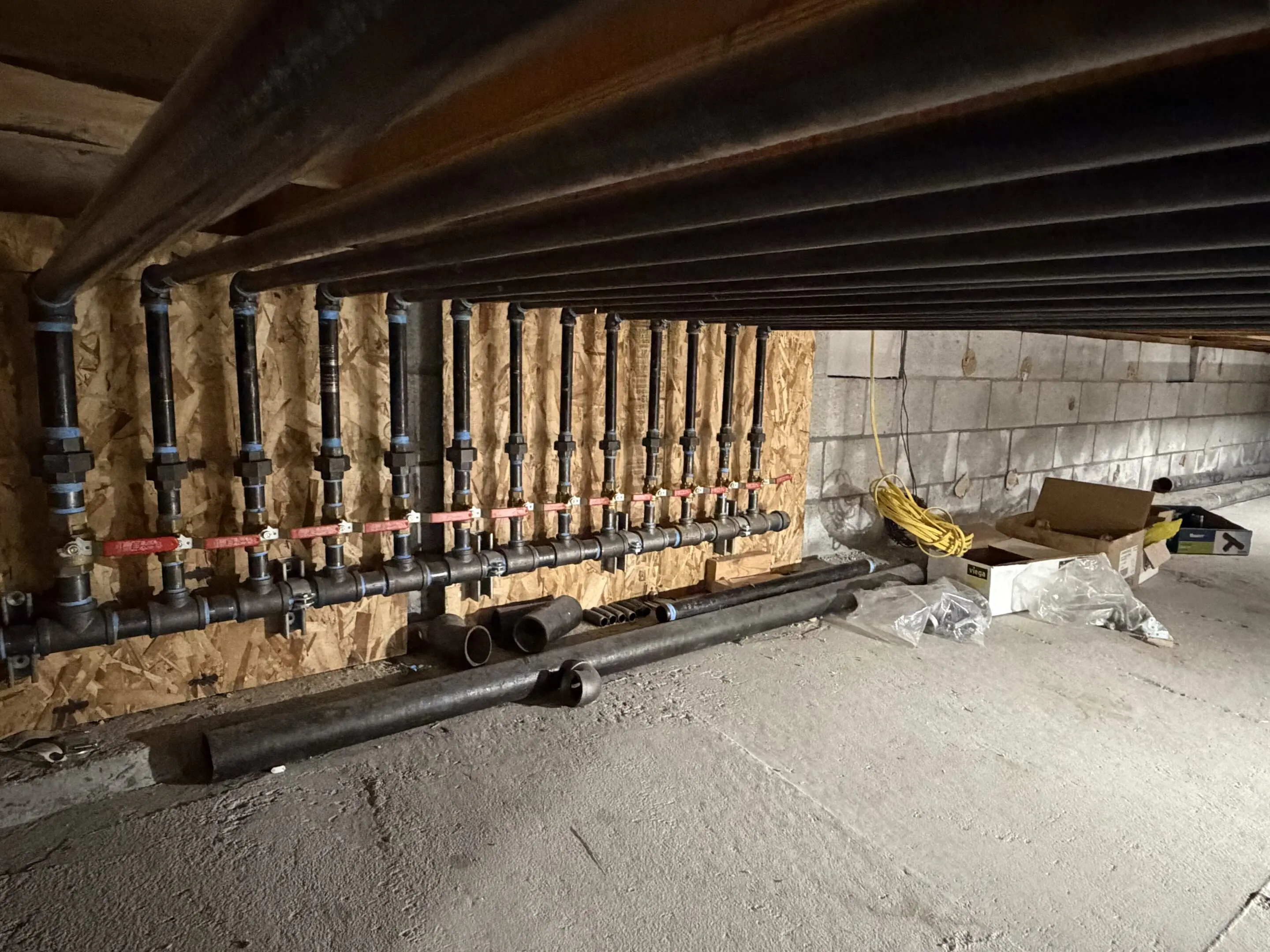 Pipes and valves in a basement setting.