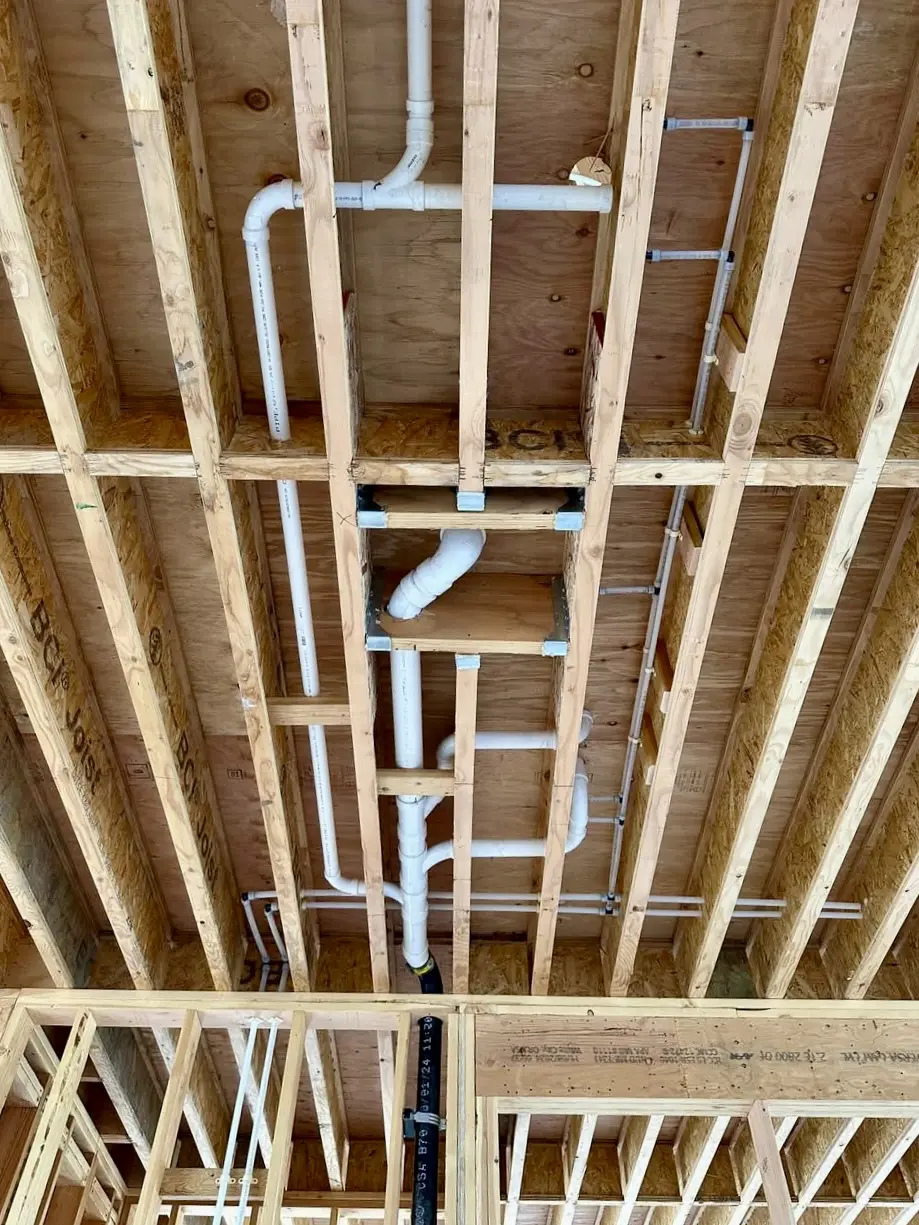 Exposed ceiling pipes and wooden beams.